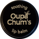 Top view of an engraved Black Slate aluminium lip balm tin with Oupa Chum’s logo and the words 'soothing' and 'lip balm'